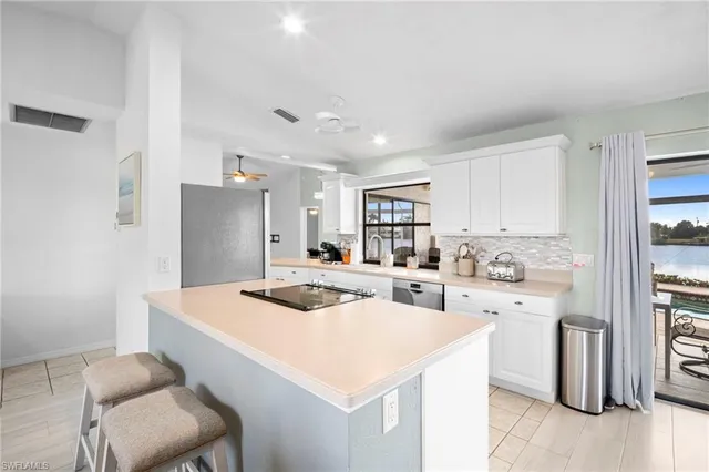 a kitchen with a stove a refrigerator and white cabinets