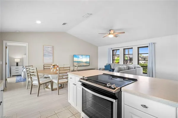 a kitchen with a stove and chairs