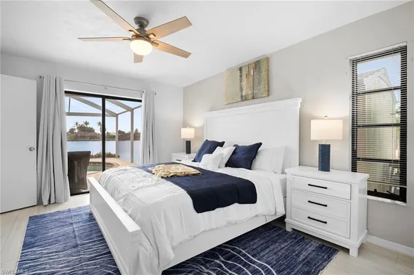 a bedroom with a large bed a chandelier and windows