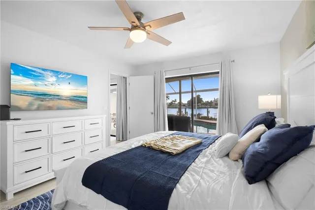 a bedroom with a bed a dresser and flat screen tv