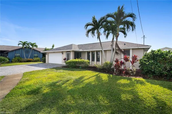 a front view of a house with a garden and yard