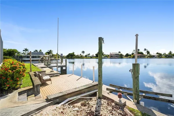 a view of a lake from a balcony with outdoor seating