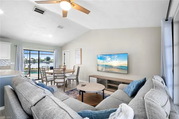 a living room with furniture large window and wall painting