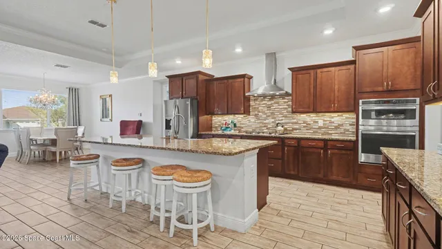 a kitchen with kitchen island granite countertop wooden cabinets and stainless steel appliances