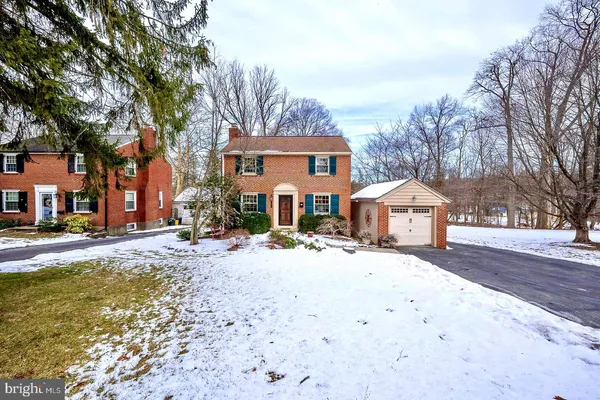 a front view of a house with a yard covered in snow