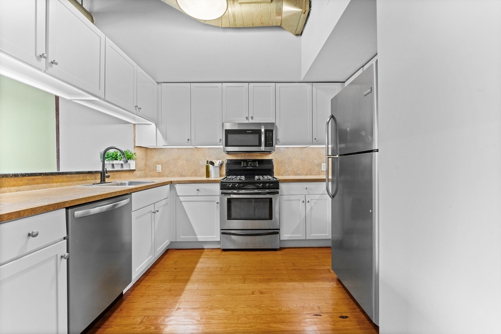 1 Envelope Terrace, Unit 110 Worcester, MA 01604 - Photo 4 of 15 a kitchen with granite countertop a refrigerator and a stove top oven