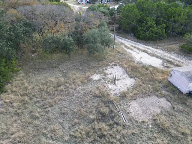 a view of a dry yard with wooden fence