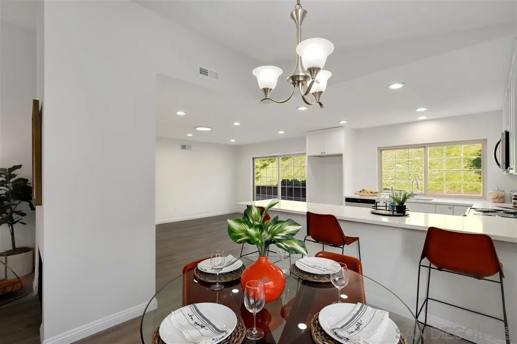 439 Mainsail Road Oceanside, CA 92054 - Photo 7 of 25 a kitchen with stainless steel appliances a dining table chairs chandelier and a window