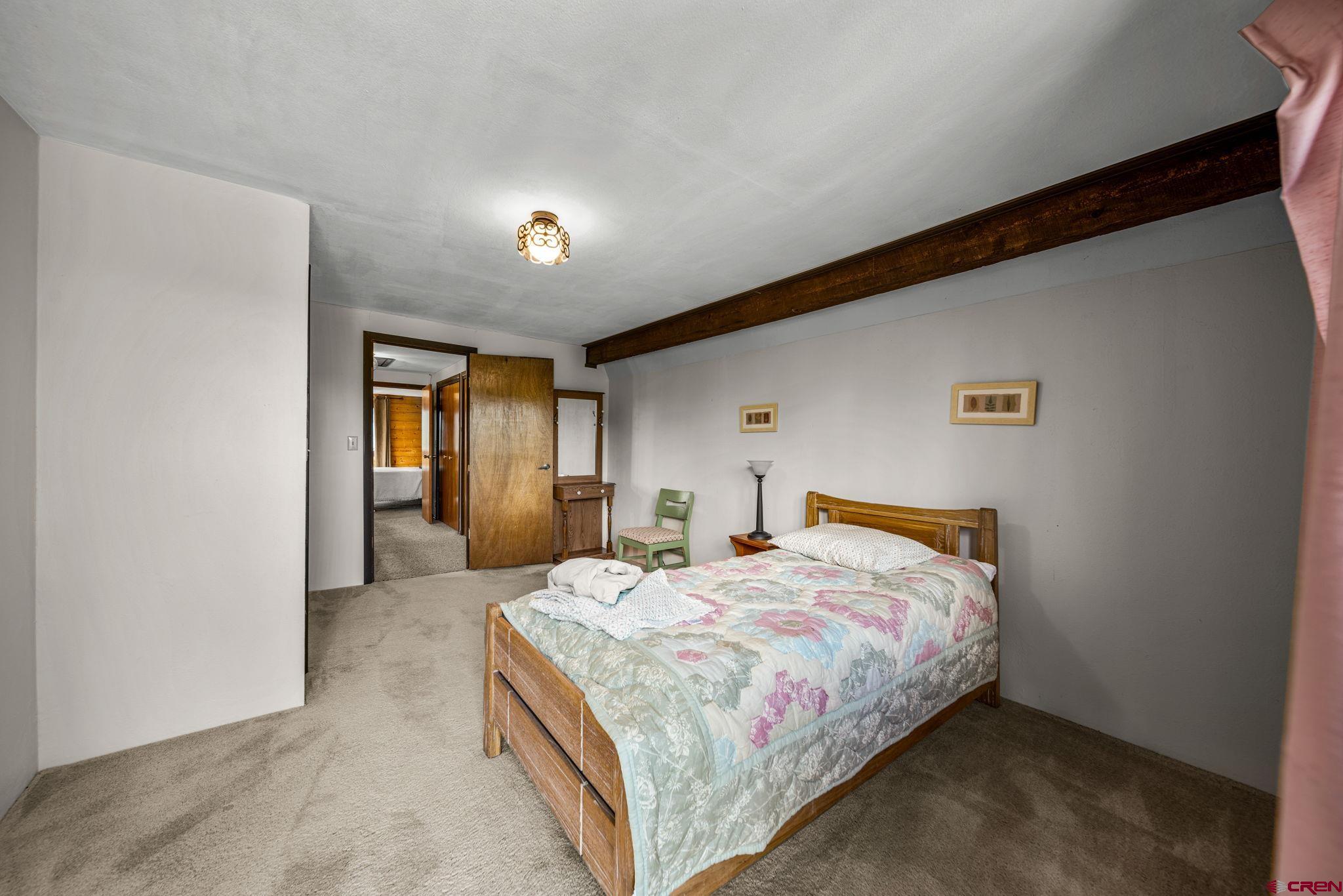 1019 Meadow Road Durango, CO 81303 - Photo 23 of 33 a bedroom with a bed and a lamp with the wall