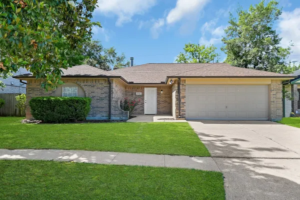 a front view of a house with a garden and yard