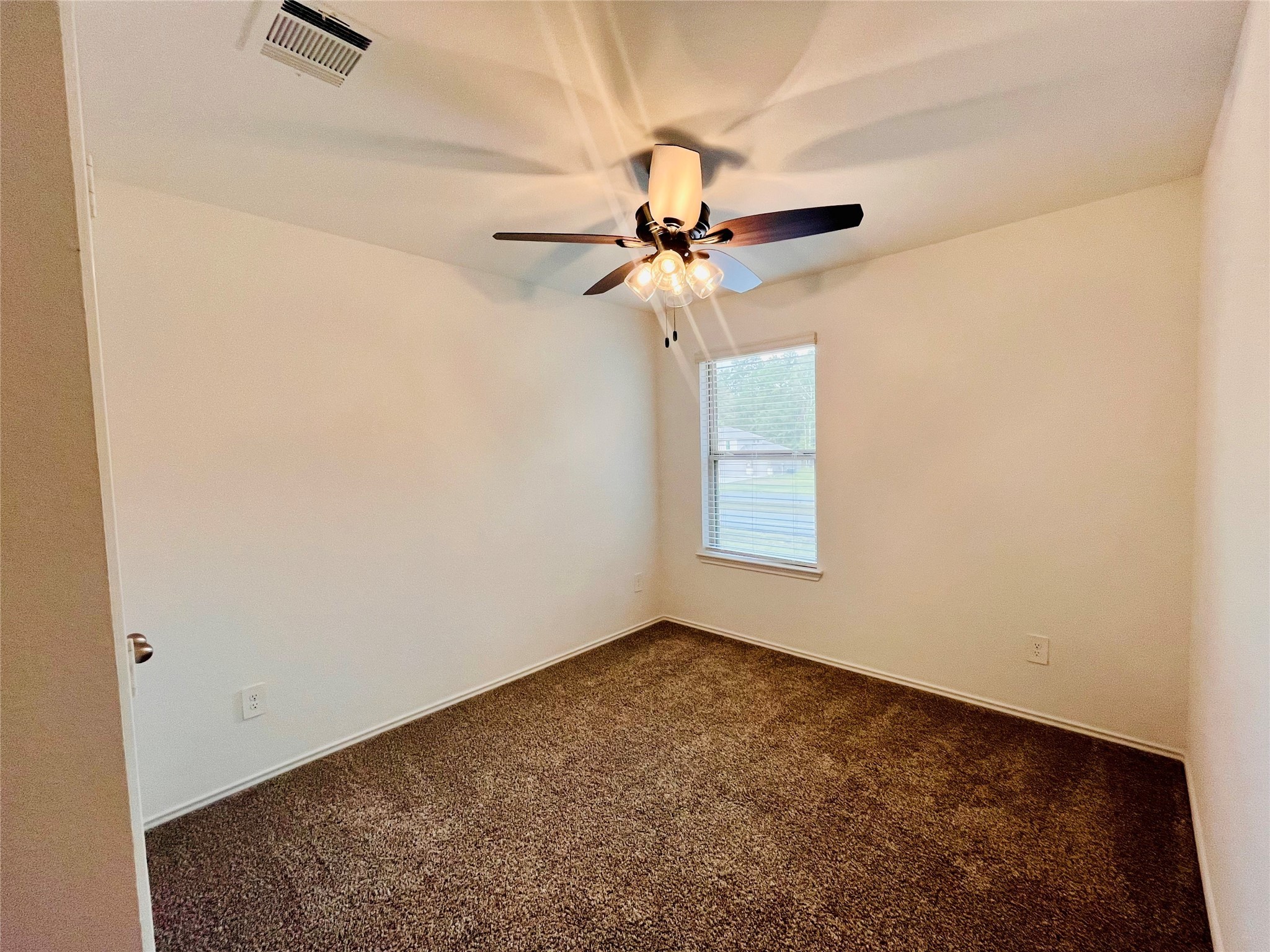 2914 Roman Forest Boulevard New Caney, TX 77357 - Photo 33 of 35 an empty room with a window and a fan