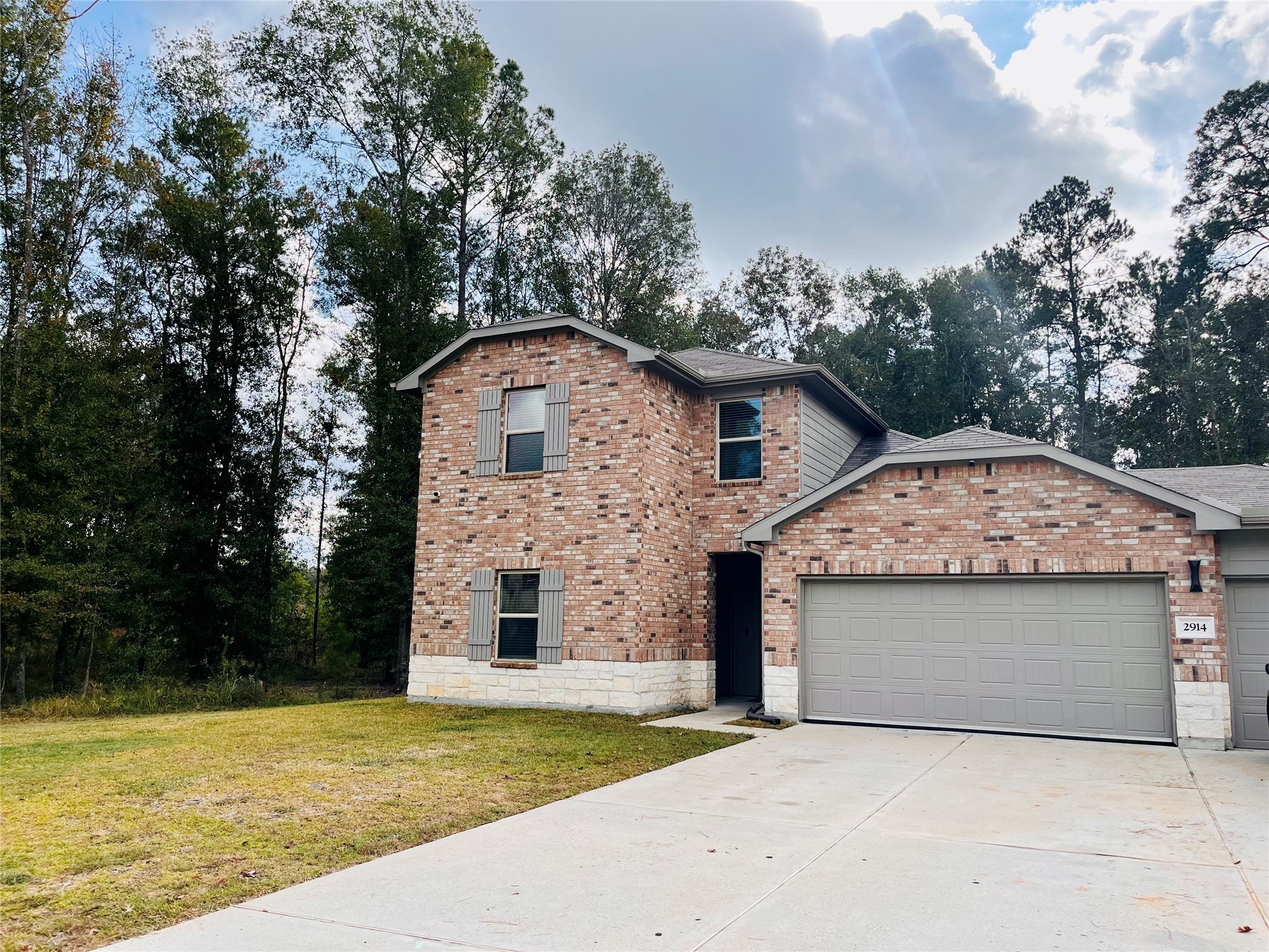 2914 Roman Forest Boulevard New Caney, TX 77357 - Photo 4 of 35 a front view of a house with a garden and trees