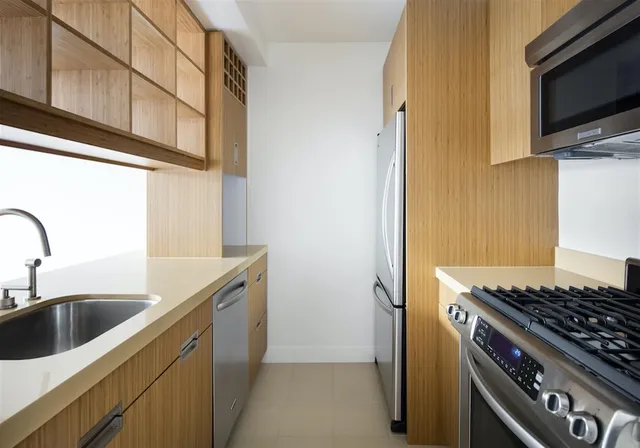 a kitchen with stainless steel appliances granite countertop a sink and a stove top oven