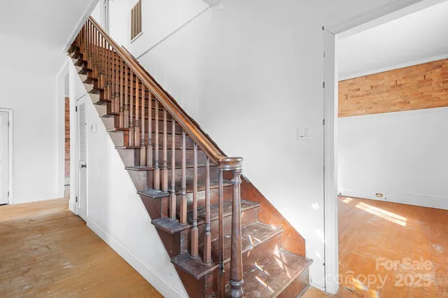 a view of staircase with wooden floor and white walls