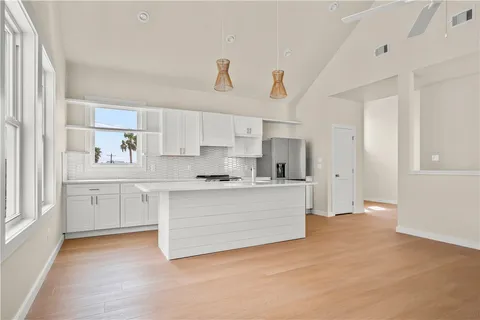a kitchen with granite countertop a sink stove and cabinets