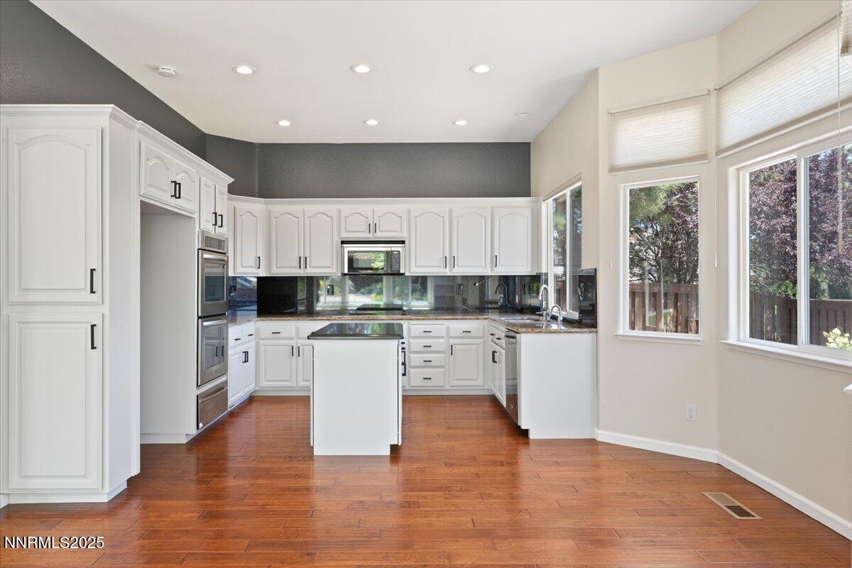 5024 East Albuquerque Road Reno, NV 89511 - Photo 11 of 27 a kitchen with white cabinets and white appliances