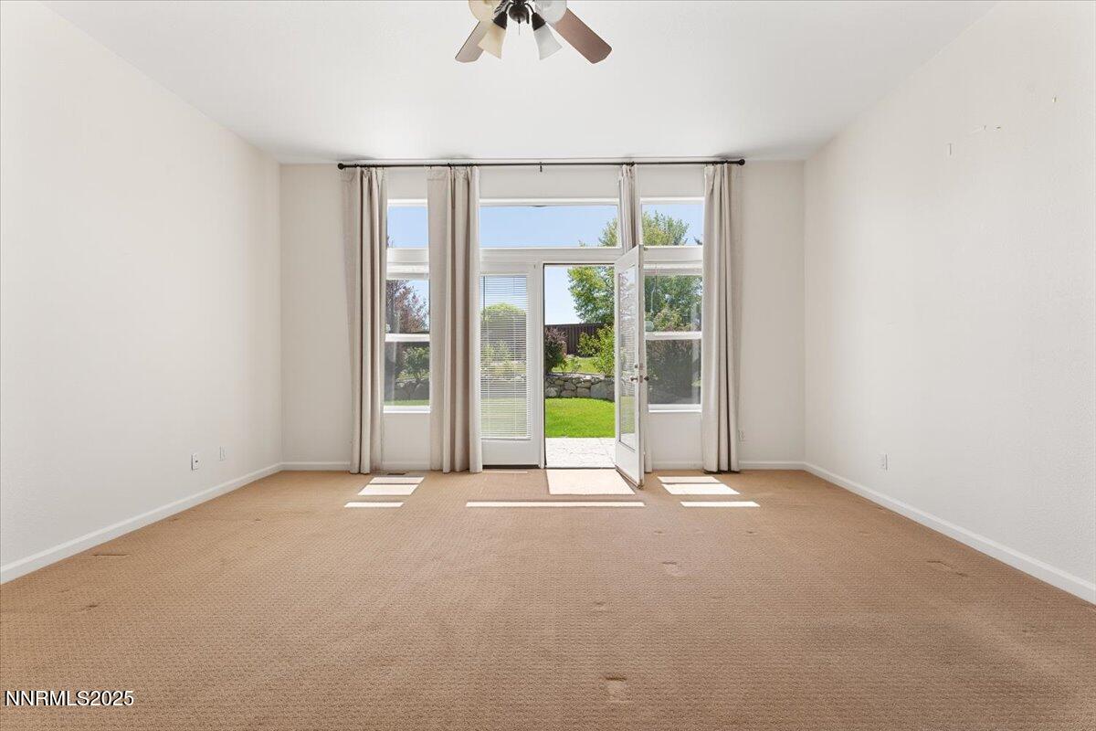 5024 East Albuquerque Road Reno, NV 89511 - Photo 15 of 27 an empty room with windows and chandelier fan