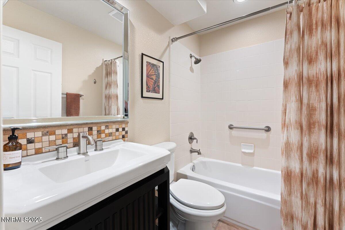 5024 East Albuquerque Road Reno, NV 89511 - Photo 17 of 27 a bathroom with a sink a toilet a mirror a bathtub and shower