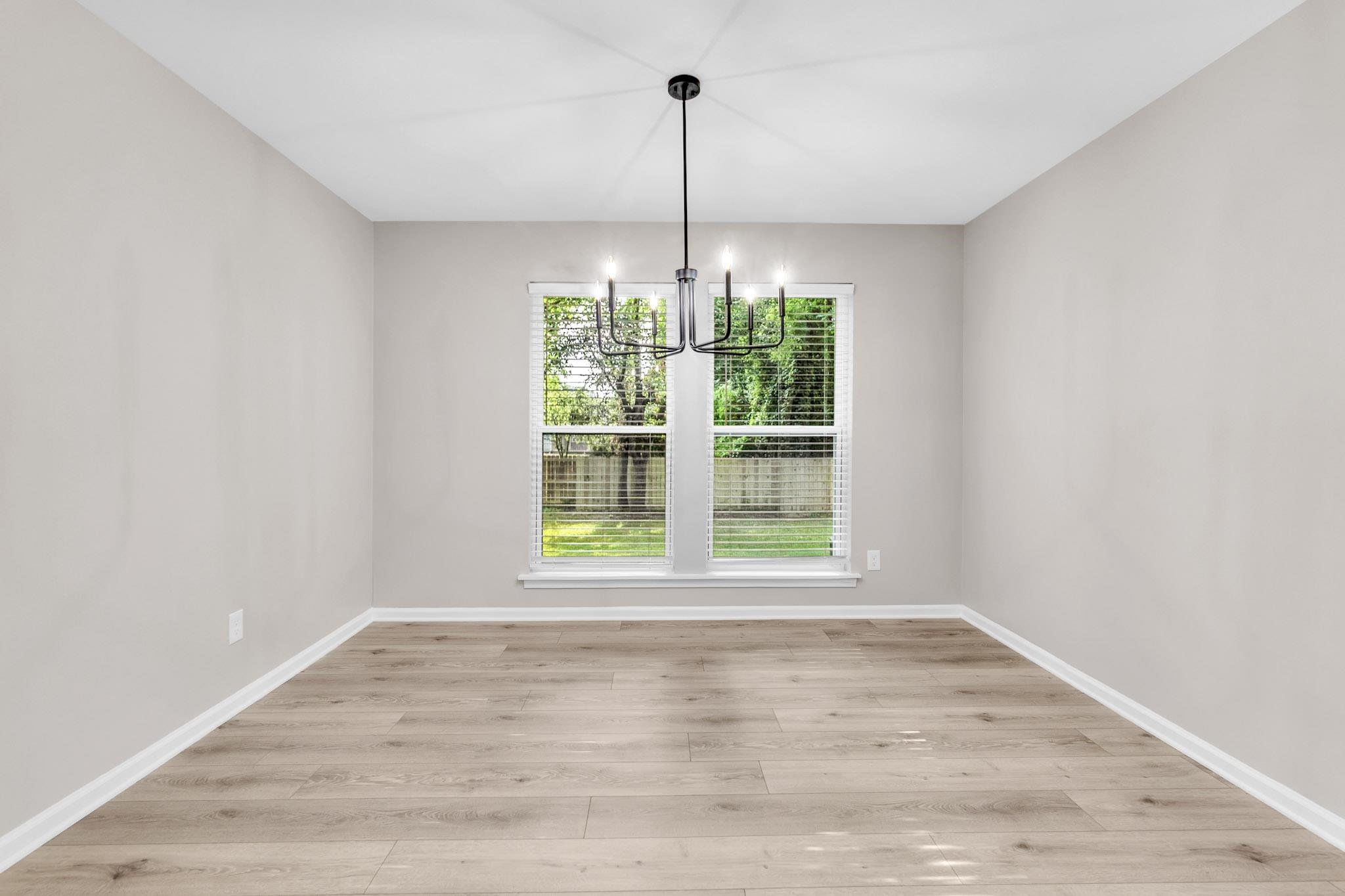 2556 Lynnfield Road Memphis, TN 38119 - Photo 16 of 24 Unfurnished dining area featuring light wood-type flooring and a chandelier