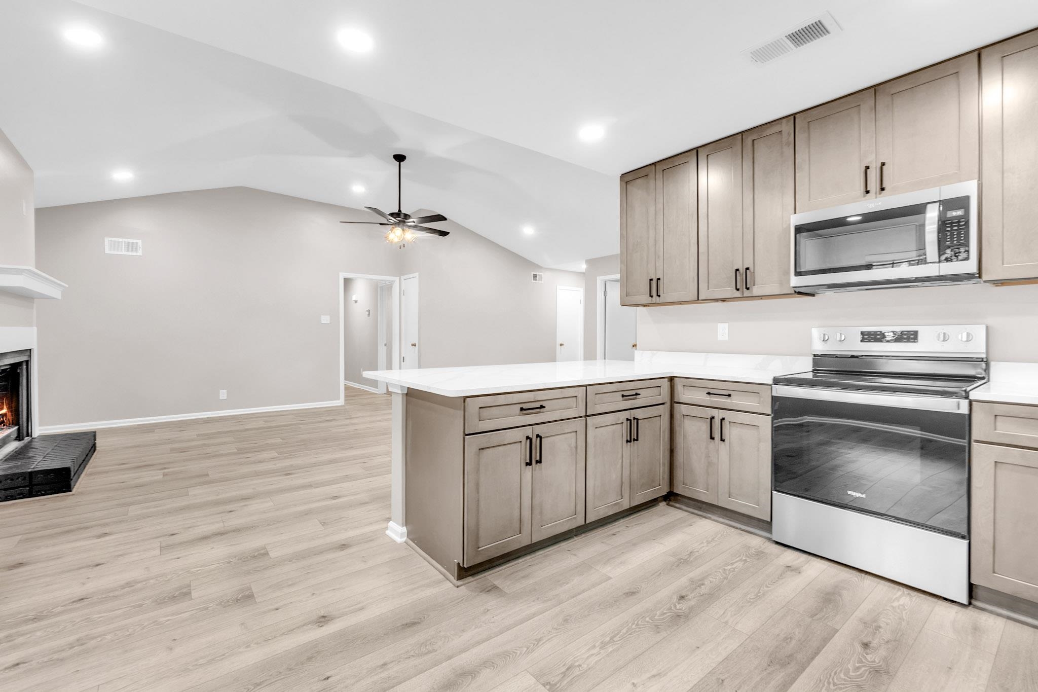2556 Lynnfield Road Memphis, TN 38119 - Photo 24 of 24 Kitchen with stainless steel appliances, recessed lighting, open floor plan, a lit fireplace, and a peninsula