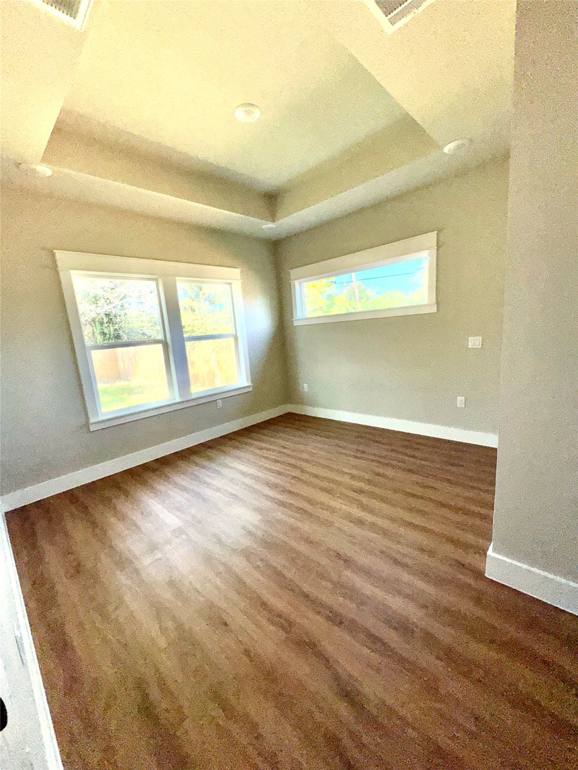 204 Booker T Washington Street, Unit B Conroe, TX 77301 - Photo 5 of 13 an empty room with wooden floor and windows