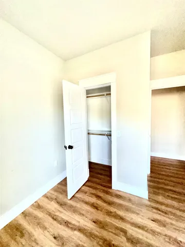 a view of a room with wooden floor and a white wall