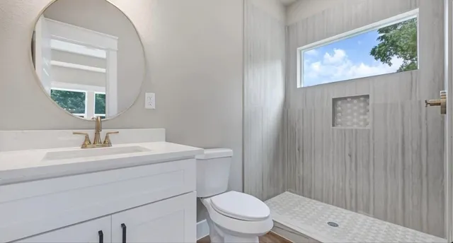 a bathroom with a toilet a sink a vanity and mirror