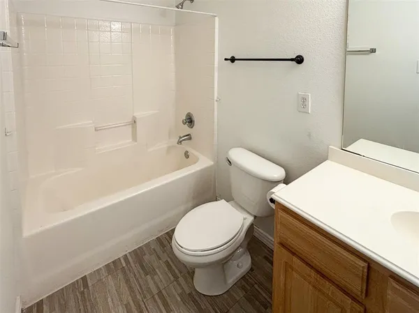 a white toilet sitting next to a bath tub