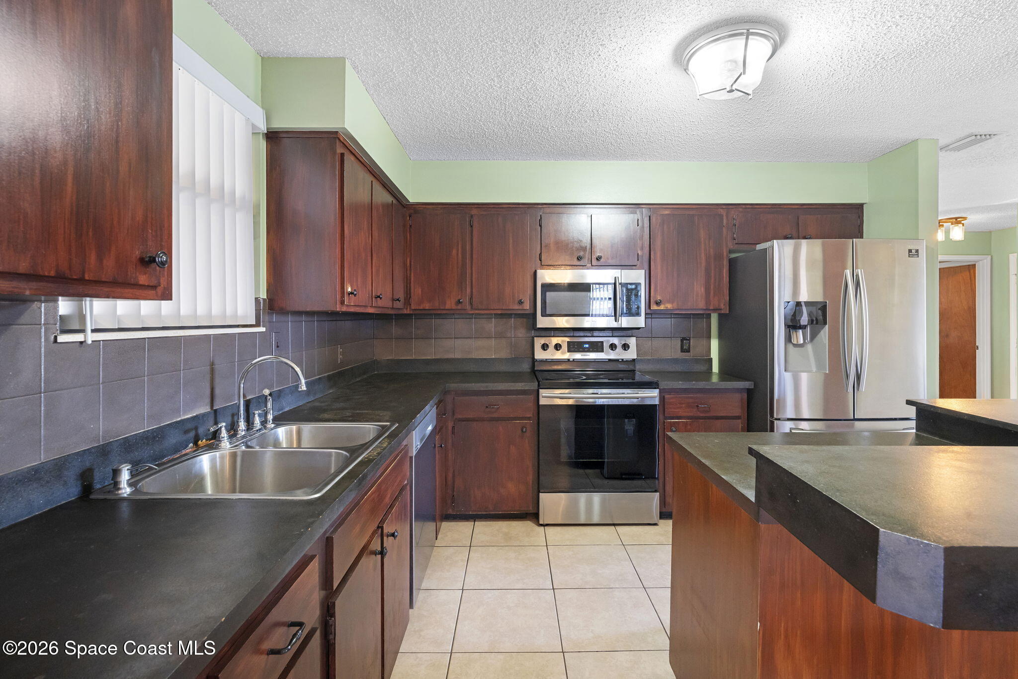 4550 Piedras Street Cocoa, FL 32927 - Photo 13 of 53 a kitchen with stainless steel appliances granite countertop a sink a stove and refrigerator