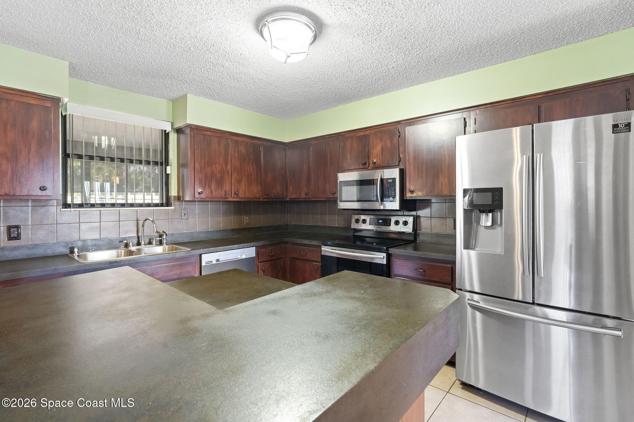 4550 Piedras Street Cocoa, FL 32927 - Photo 14 of 53 a kitchen with a refrigerator sink and microwave