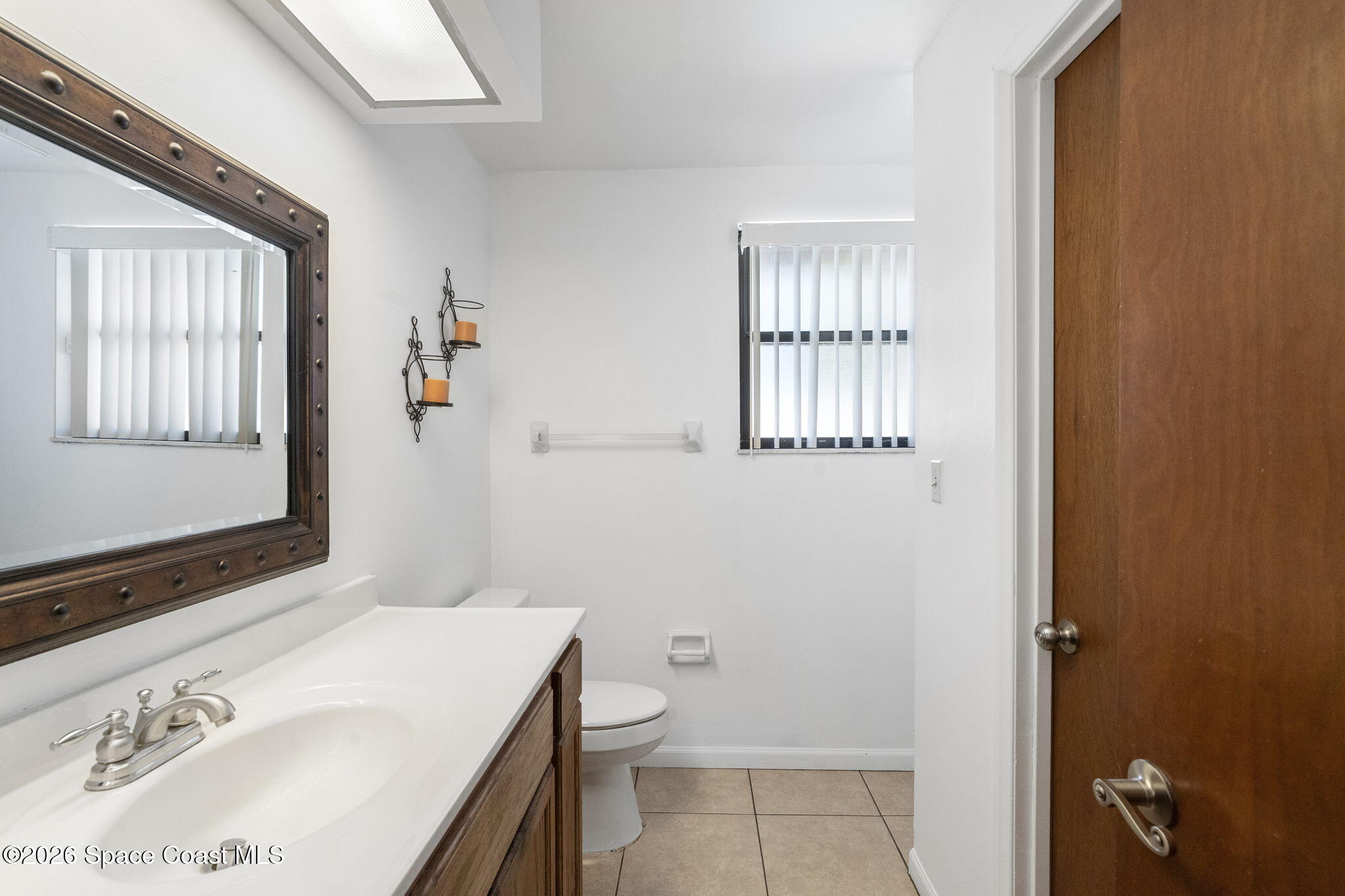 4550 Piedras Street Cocoa, FL 32927 - Photo 22 of 53 a bathroom with a sink toilet and window