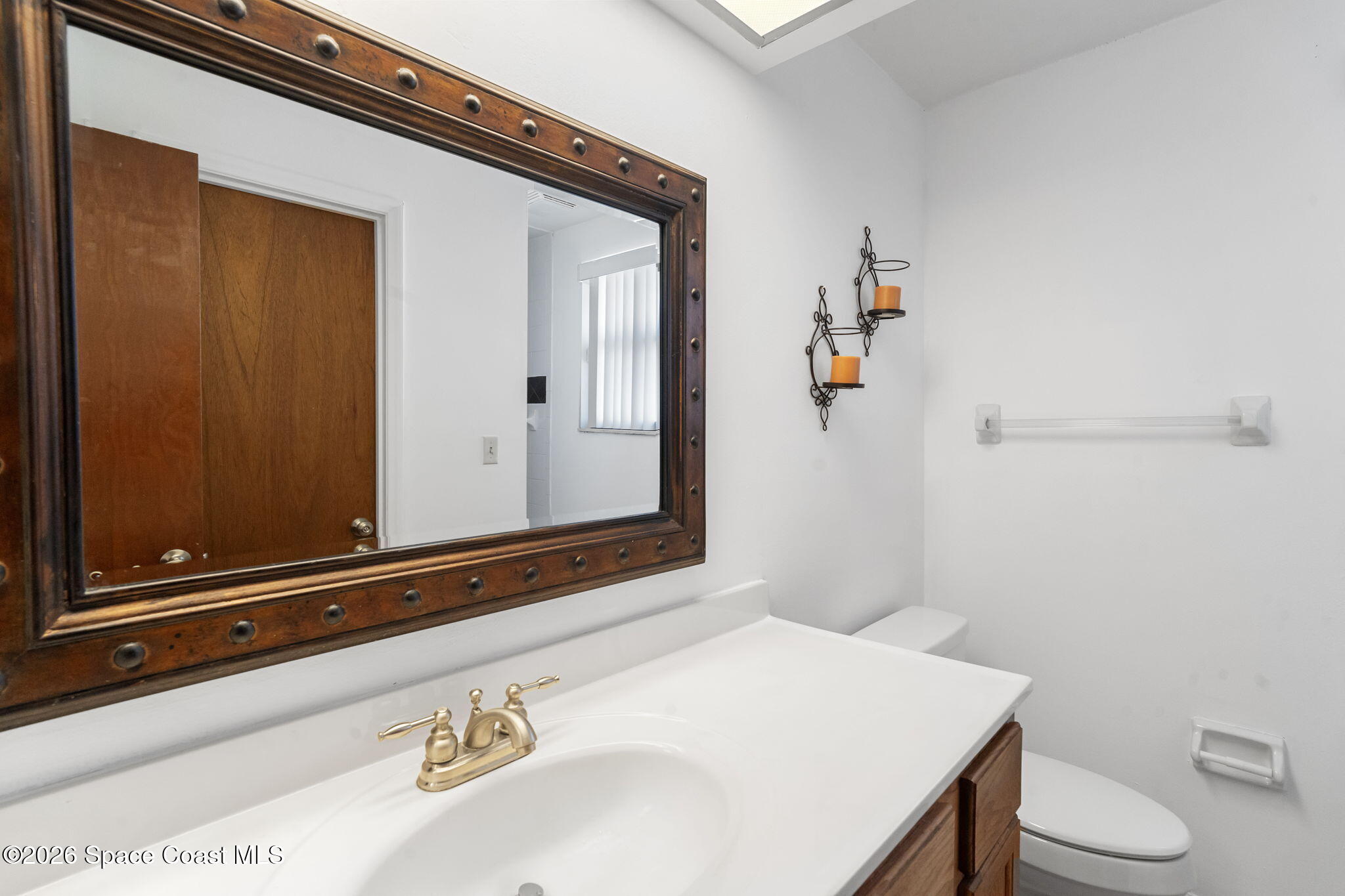4550 Piedras Street Cocoa, FL 32927 - Photo 23 of 53 a bathroom with a sink a toilet and mirror