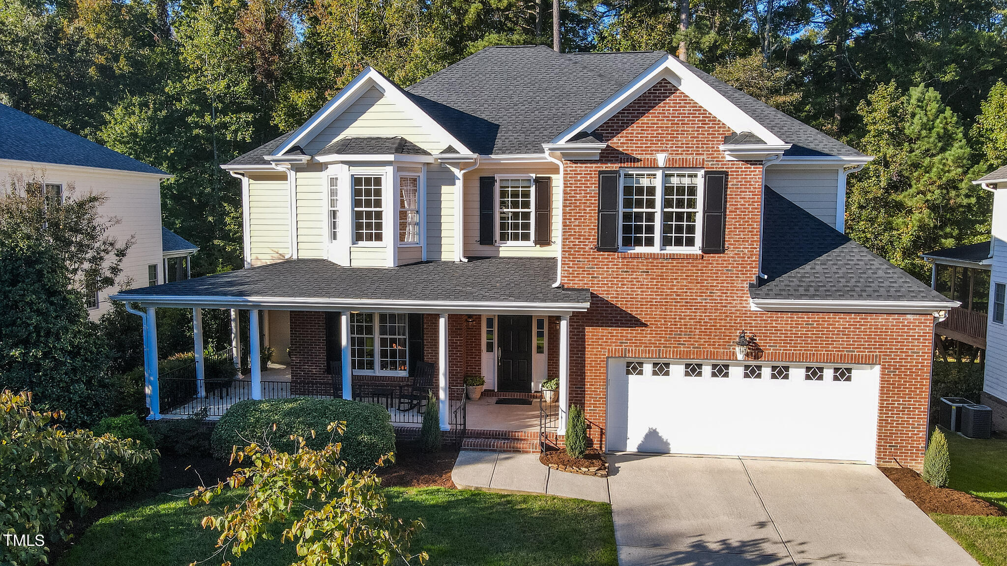 a front view of a house with a yard and trees