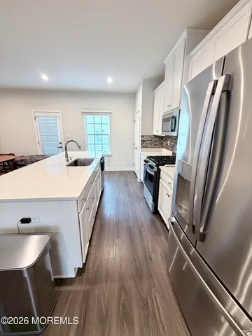 a large kitchen with lots of counter space a sink a window and stainless steel appliances