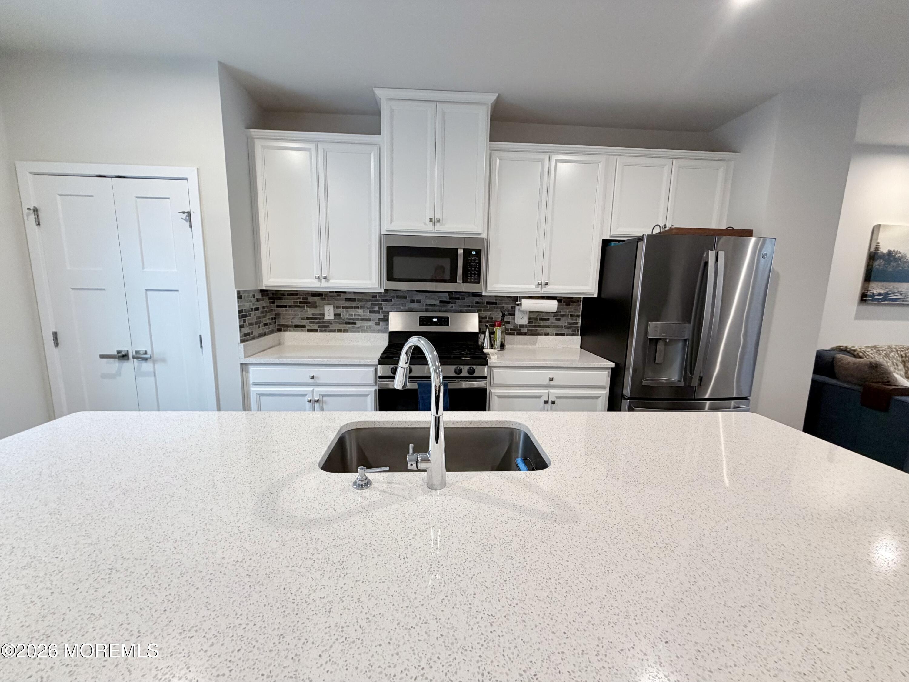 1207 English Lane, Unit 1207 Parlin, NJ 08859 - Photo 14 of 56 a kitchen with stainless steel appliances a refrigerator sink and stove