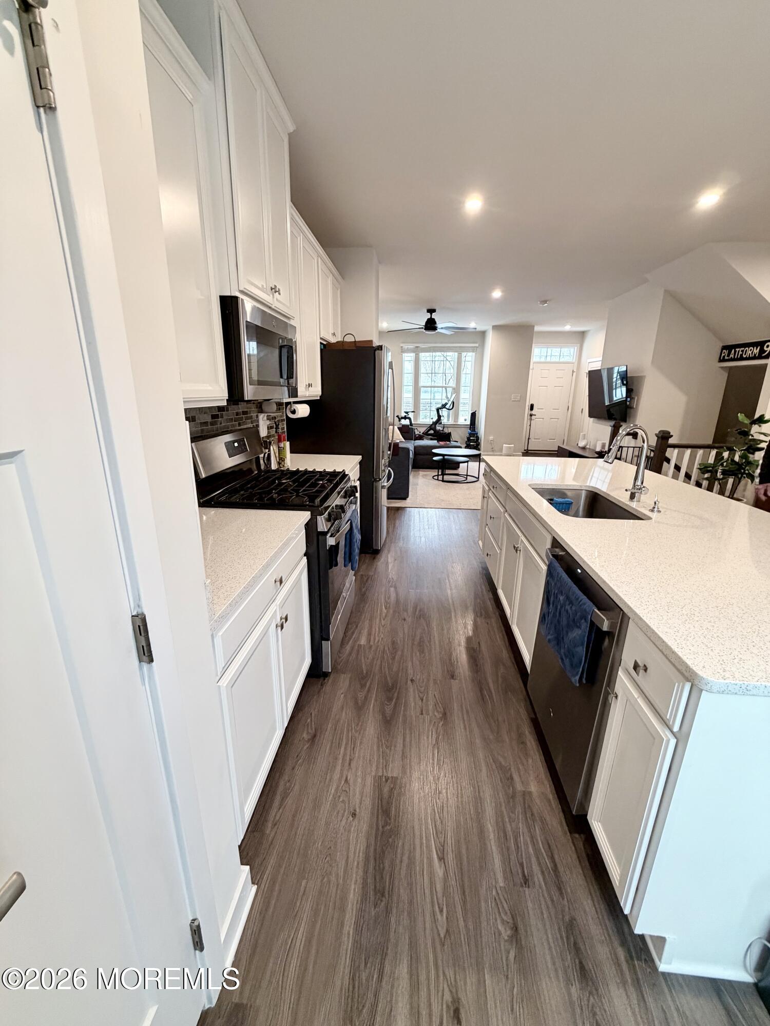 1207 English Lane, Unit 1207 Parlin, NJ 08859 - Photo 15 of 56 a large kitchen with a lot of counter space a sink wooden floor and stainless steel appliances