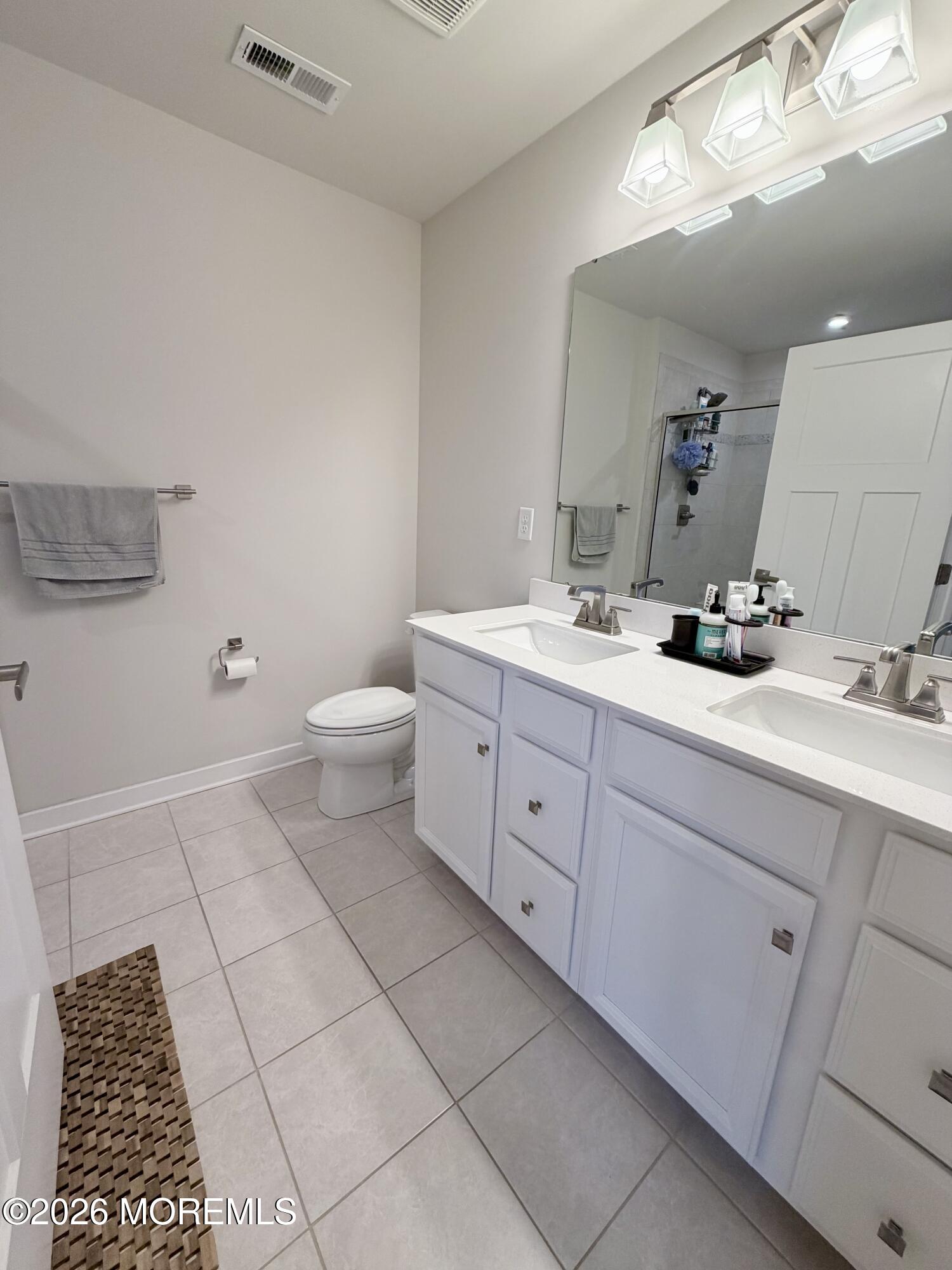 1207 English Lane, Unit 1207 Parlin, NJ 08859 - Photo 40 of 56 a bathroom with a double vanity sink a toilet and a mirror