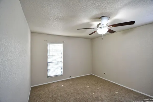a view of an empty room with a fireplace and a window