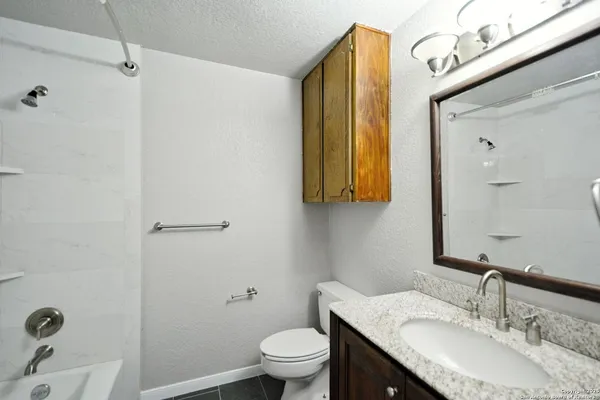 a bathroom with a granite countertop sink and a mirror