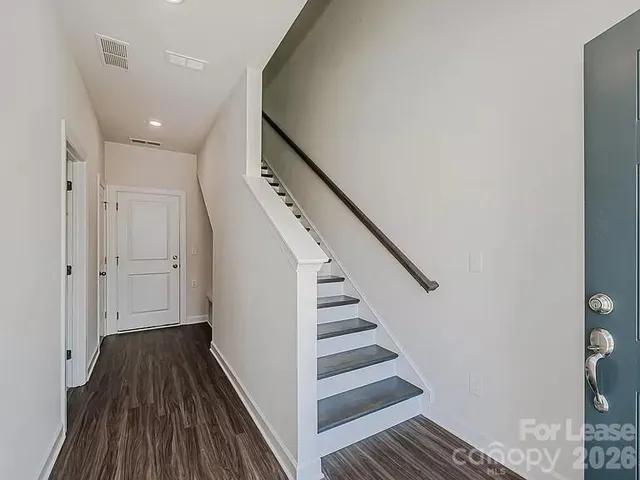 a view of a hallway with wooden floor and staircase