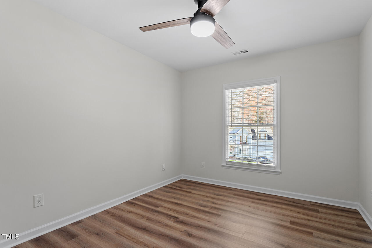 9004 Admaston Drive Raleigh, NC 27613 - Photo 26 of 30 Bedroom 2 with new LVP flooring and a ceiling fan.