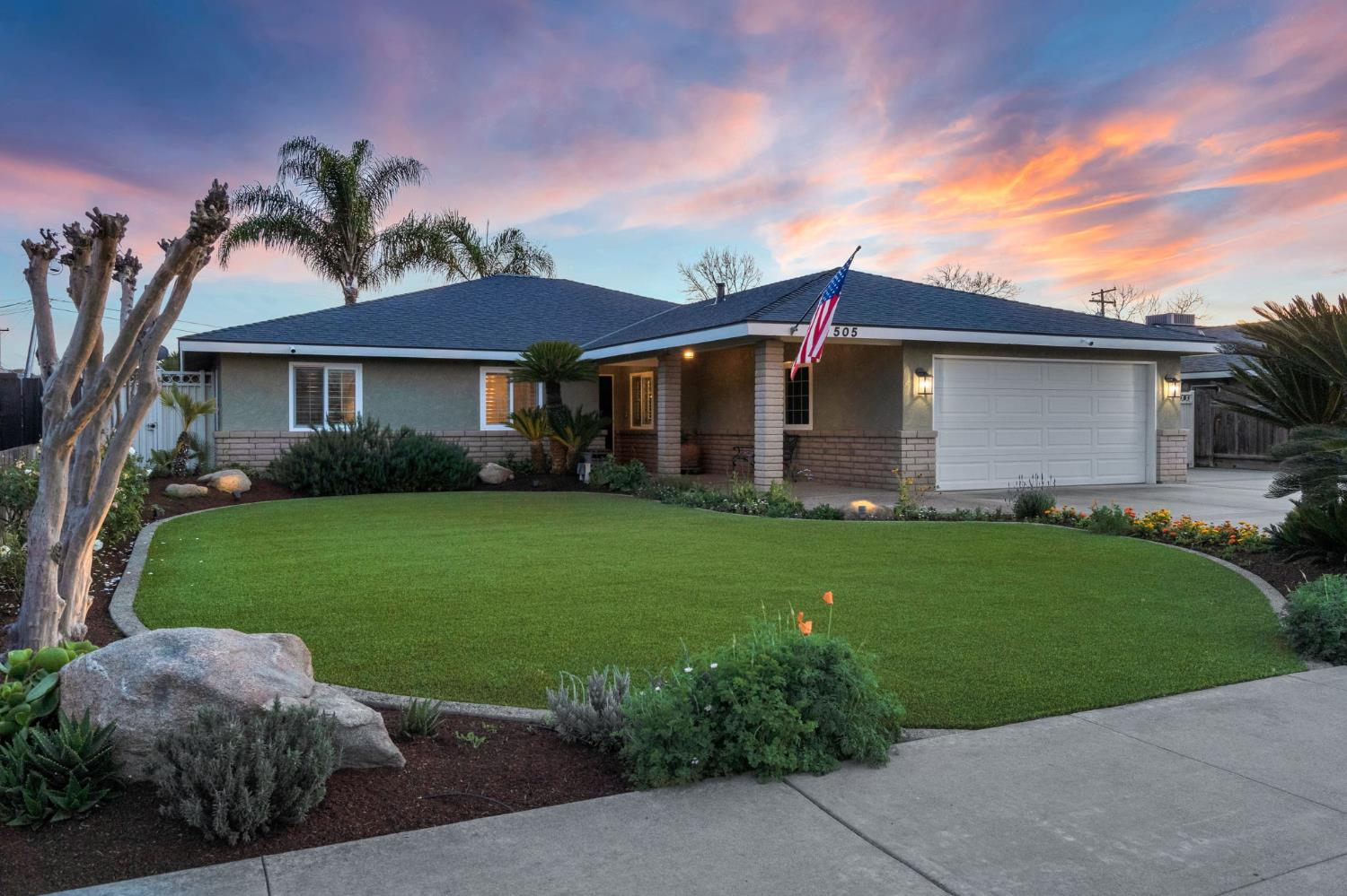 505 Ash Street Lemoore, CA 93245 - Photo 1 of 66 a front view of a house with a garden and yard