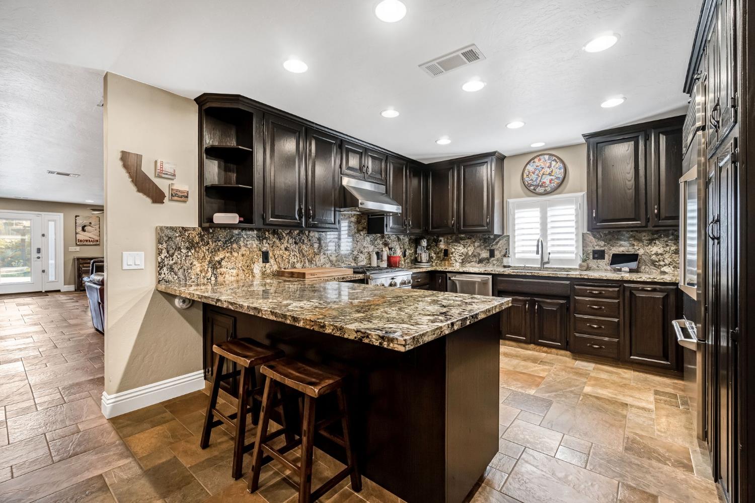 505 Ash Street Lemoore, CA 93245 - Photo 16 of 66 a kitchen with granite countertop cabinets a counter space and stainless steel appliances
