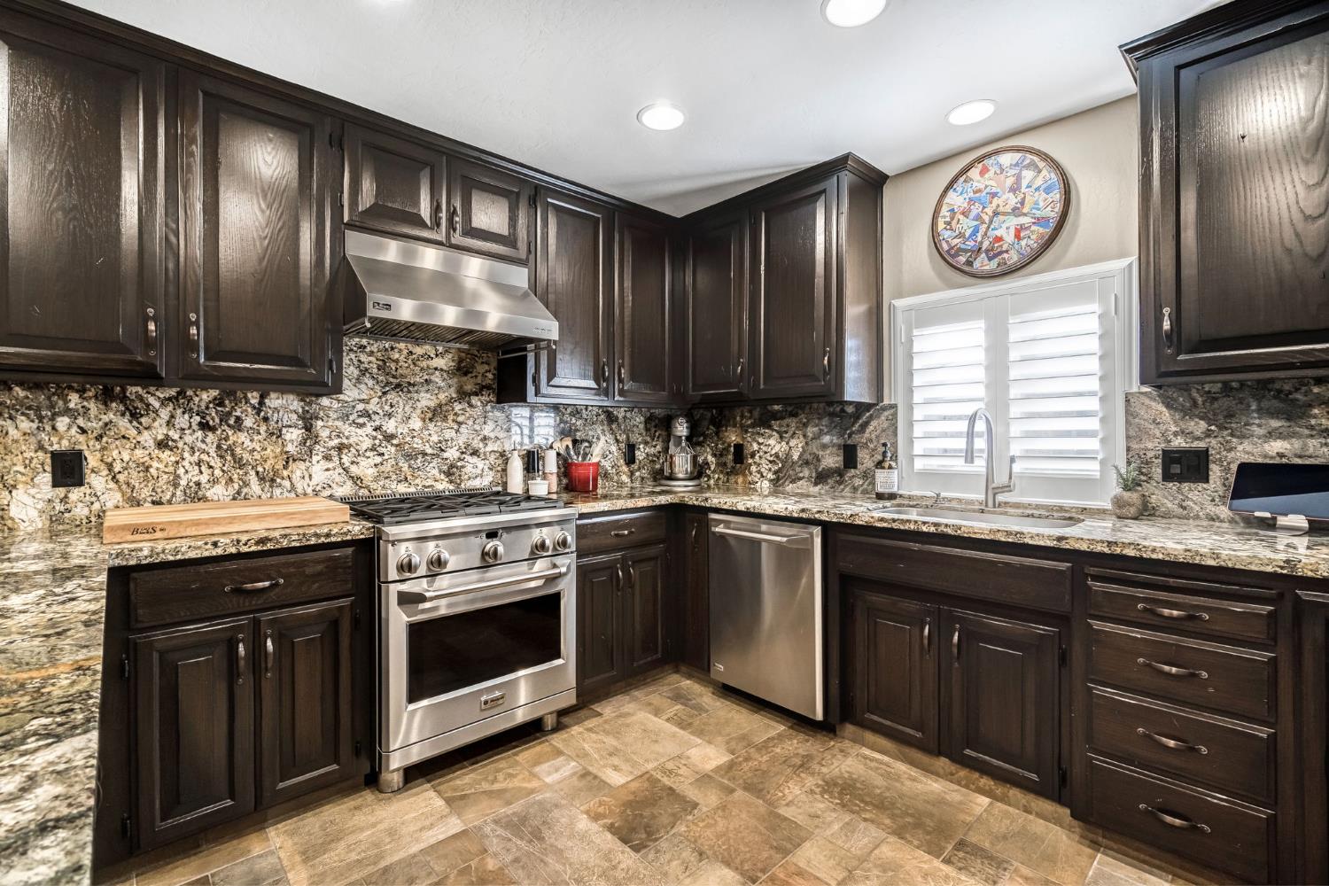 505 Ash Street Lemoore, CA 93245 - Photo 17 of 66 a kitchen with granite countertop wooden cabinets and stainless steel appliances