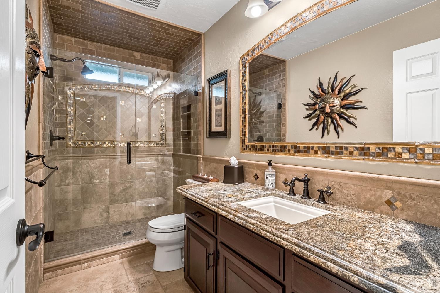 505 Ash Street Lemoore, CA 93245 - Photo 26 of 66 a bathroom with a granite countertop sink toilet a mirror and shower