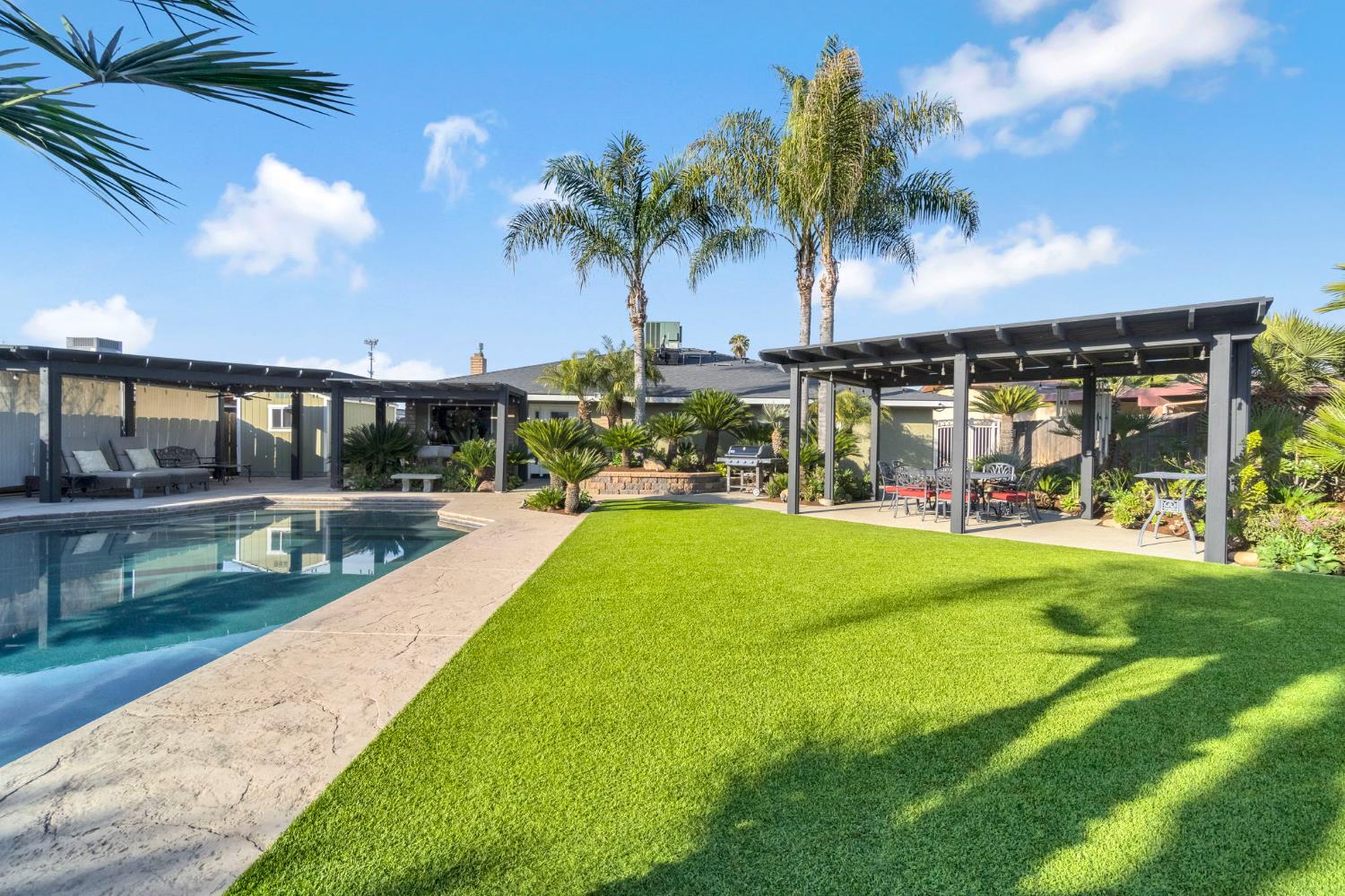 505 Ash Street Lemoore, CA 93245 - Photo 39 of 66 a view of a swimming pool with a patio and a yard