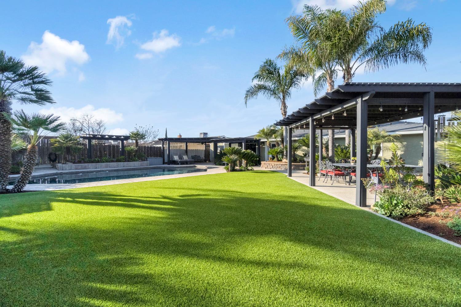 505 Ash Street Lemoore, CA 93245 - Photo 40 of 66 a swimming pool with outdoor seating and garden