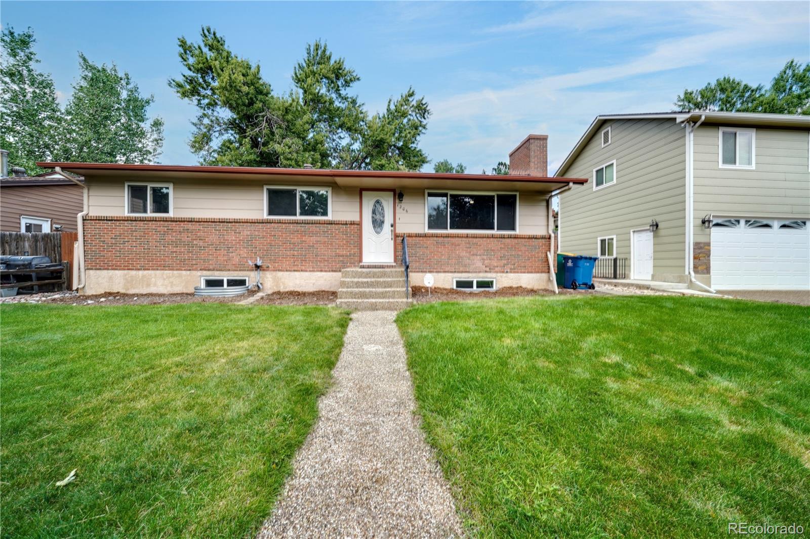 1206 Westmoreland Road Colorado Springs, CO 80907 - Photo 1 of 33 a front view of a house with a yard and garage