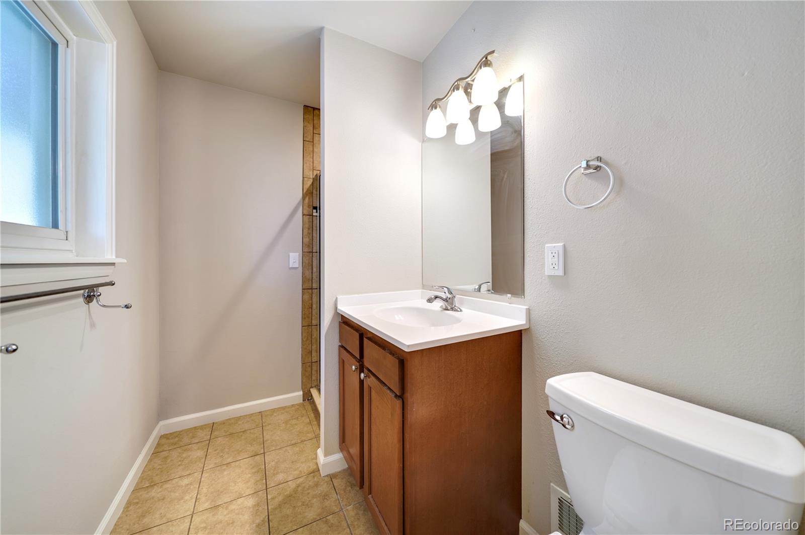 1206 Westmoreland Road Colorado Springs, CO 80907 - Photo 12 of 33 a bathroom with a sink a toilet and mirror