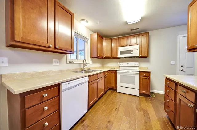 a kitchen with white cabinets appliances and a sink